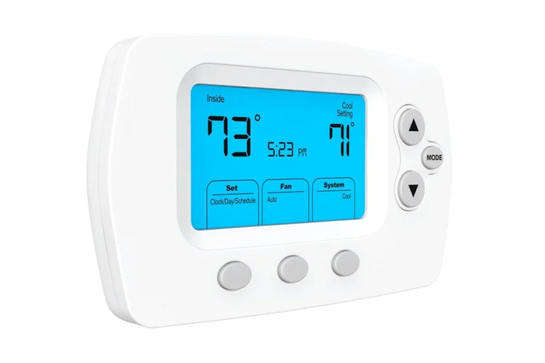 A digital thermostat displaying an indoor temperature of 73°F and a cool setting of 71°F. The time shown is 5:23 PM. The device has buttons labeled with functions.